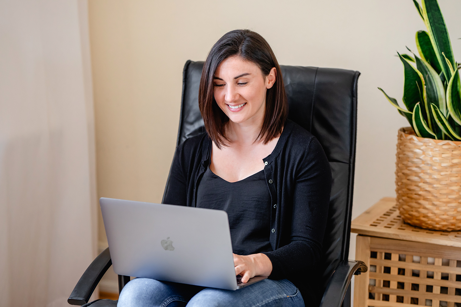 Katharina Colle sitzt auf einem Sessel und tippt etwas in ihren Laptop